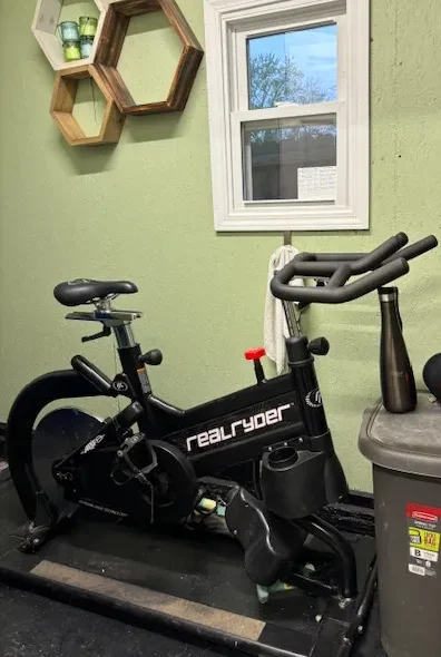 A stationary bike in the corner of a room.